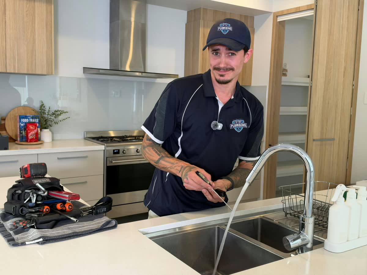 Tip Top Plumbing plumber with water running at a kitchen sink